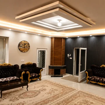 نشیمن اصلی با مبلمان کلاسیک، شومینه و سقف کناف