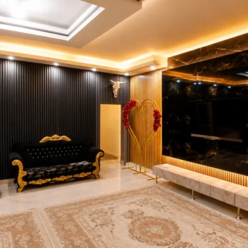سالن پذیرایی با دیوار سنگ مرمر مشکی و نورپردازی مخفی سقف